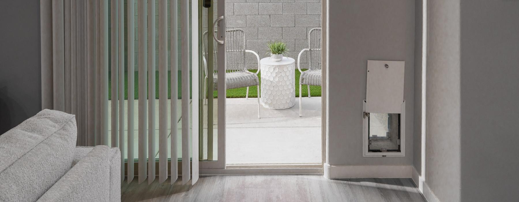 view out to a patio sliding door with chairs and a table set up outside