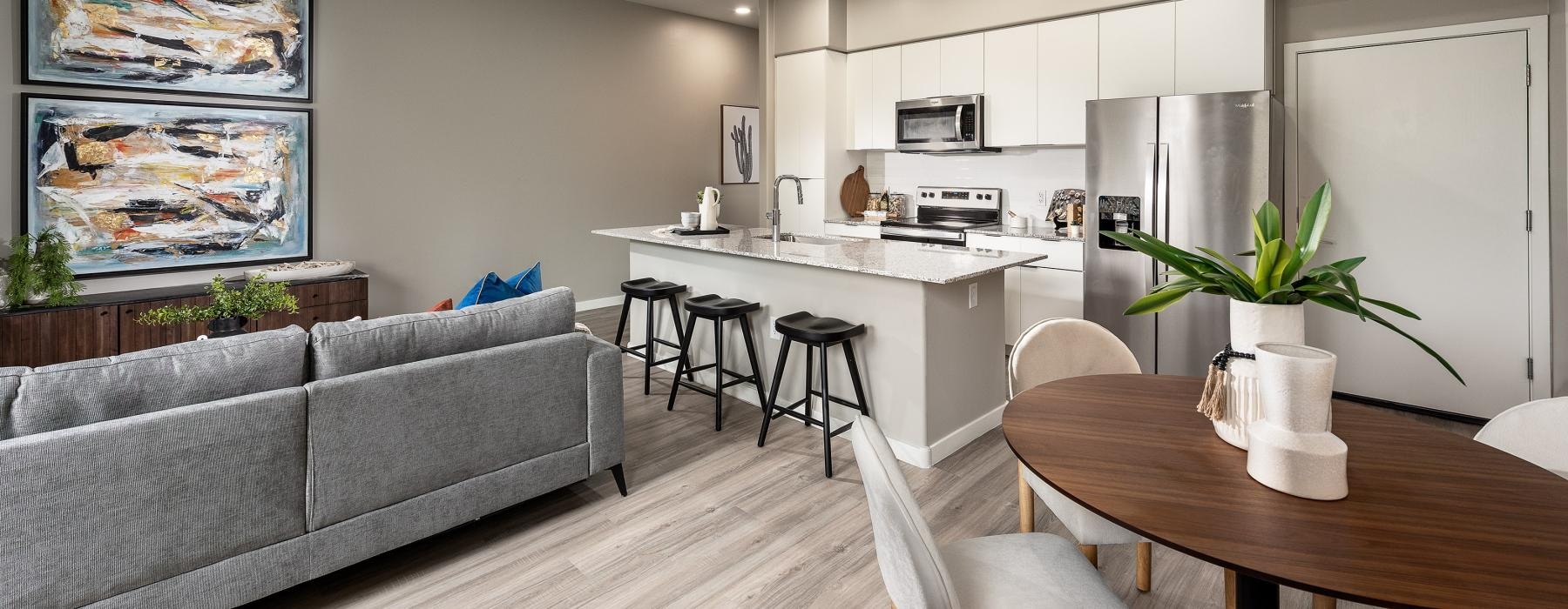 a living room with a couch, dining table and view straight into the kitchen 